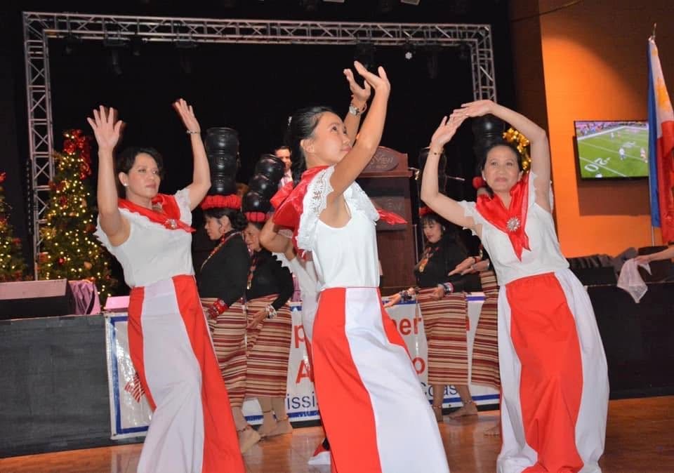 Community performers dancing onstage during a Filipino cultural celebration.