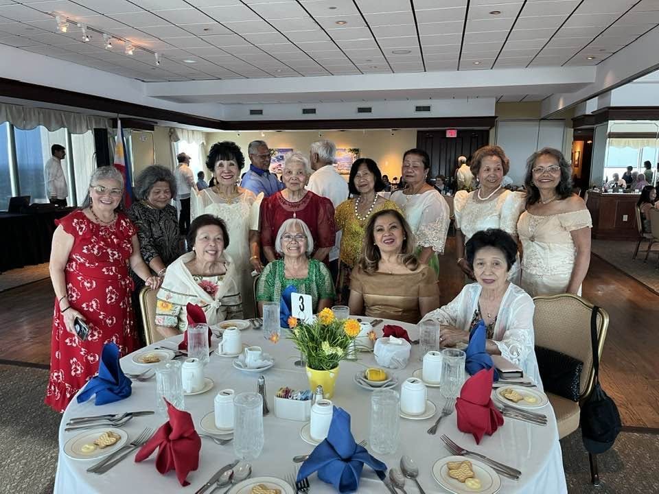 Community members seated together around a banquet table at a Filipino-American gathering.