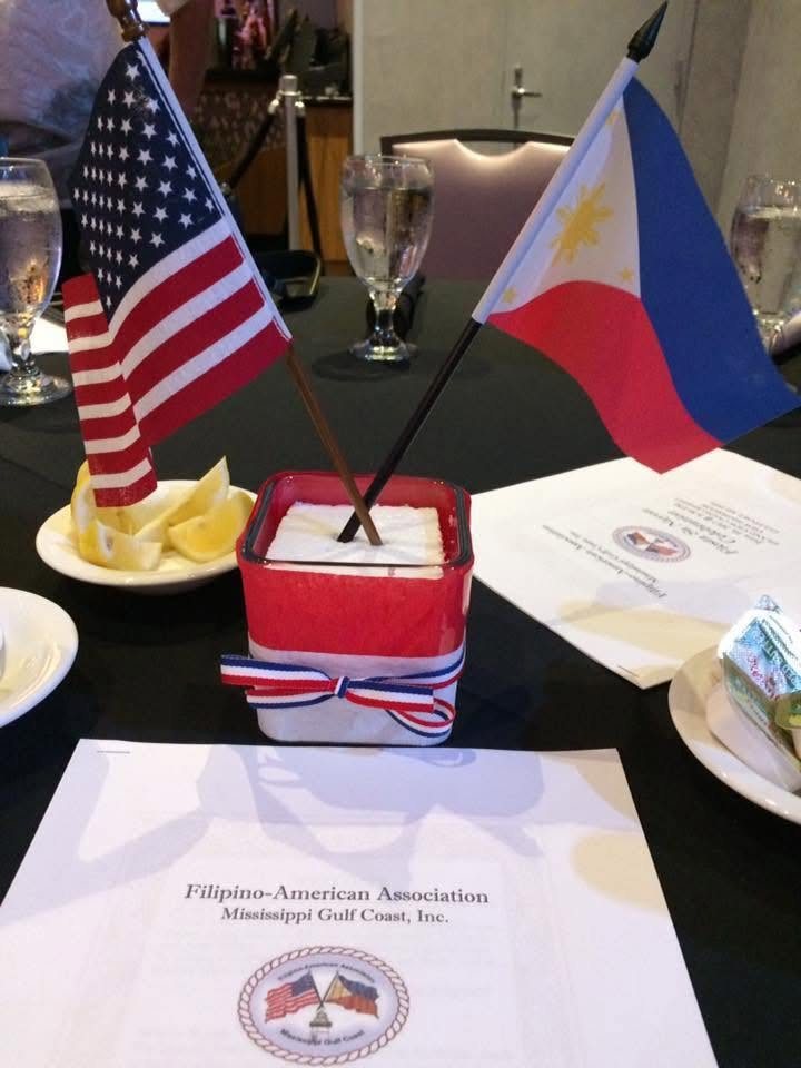 American and Philippine flags displayed together on a table at a community event.