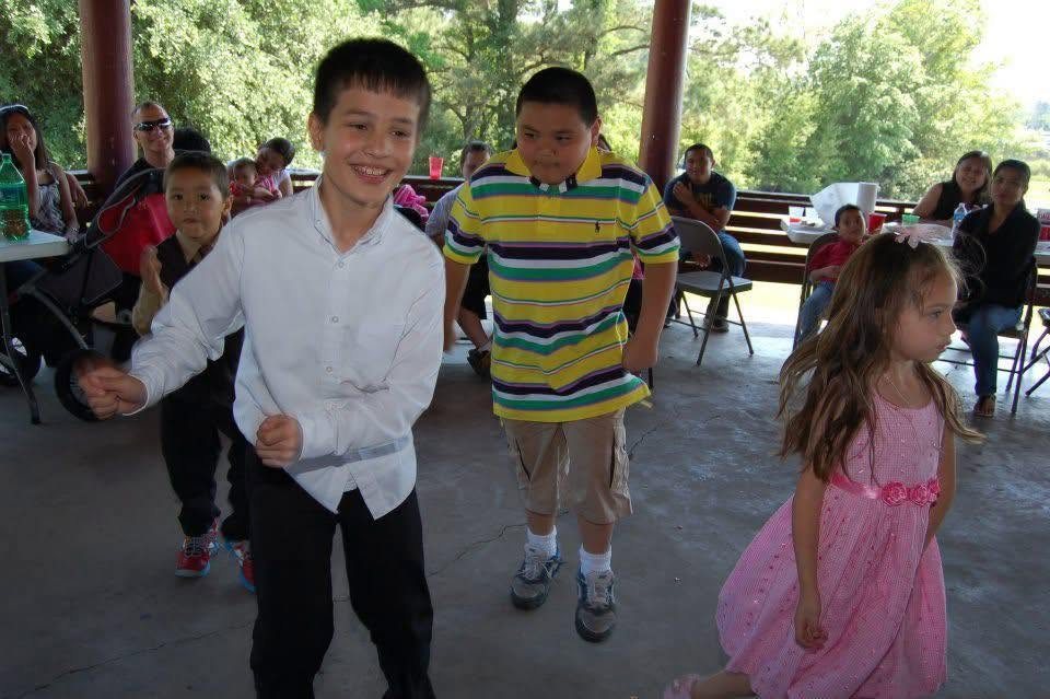 Children participating in a group activity under a pavilion during a community event.